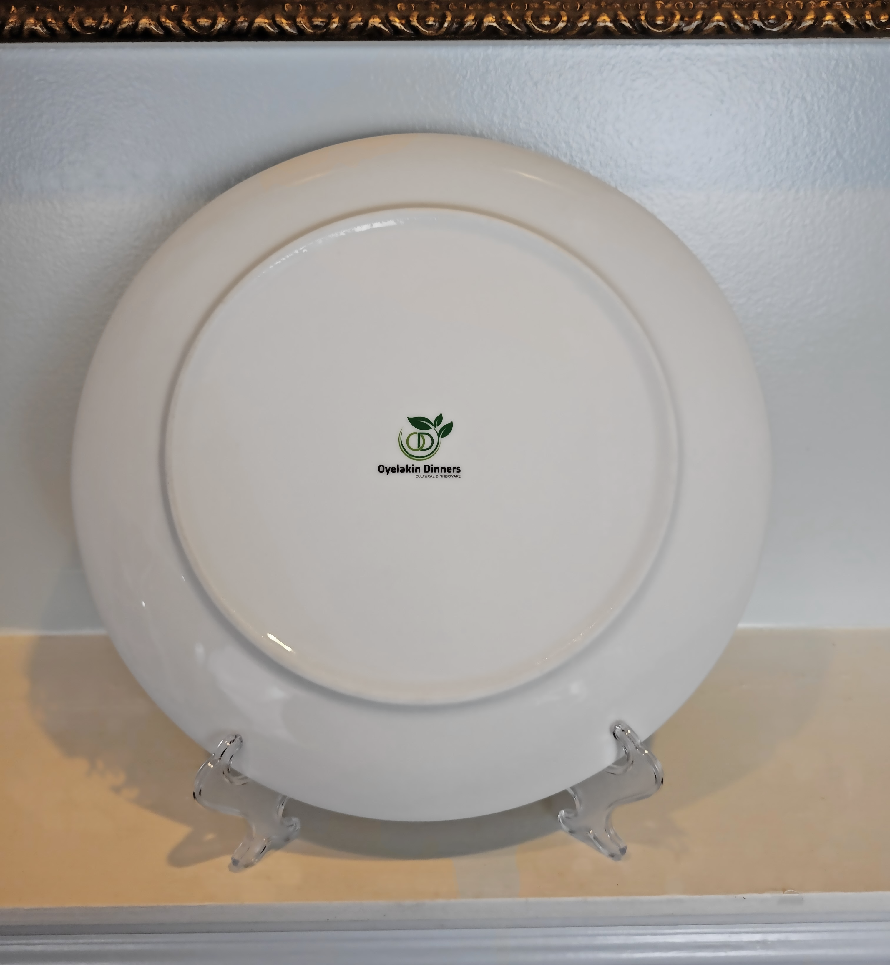This is displaying the back of a dinner plate placed on a plate easel. The back of the plate shows the brand logo 