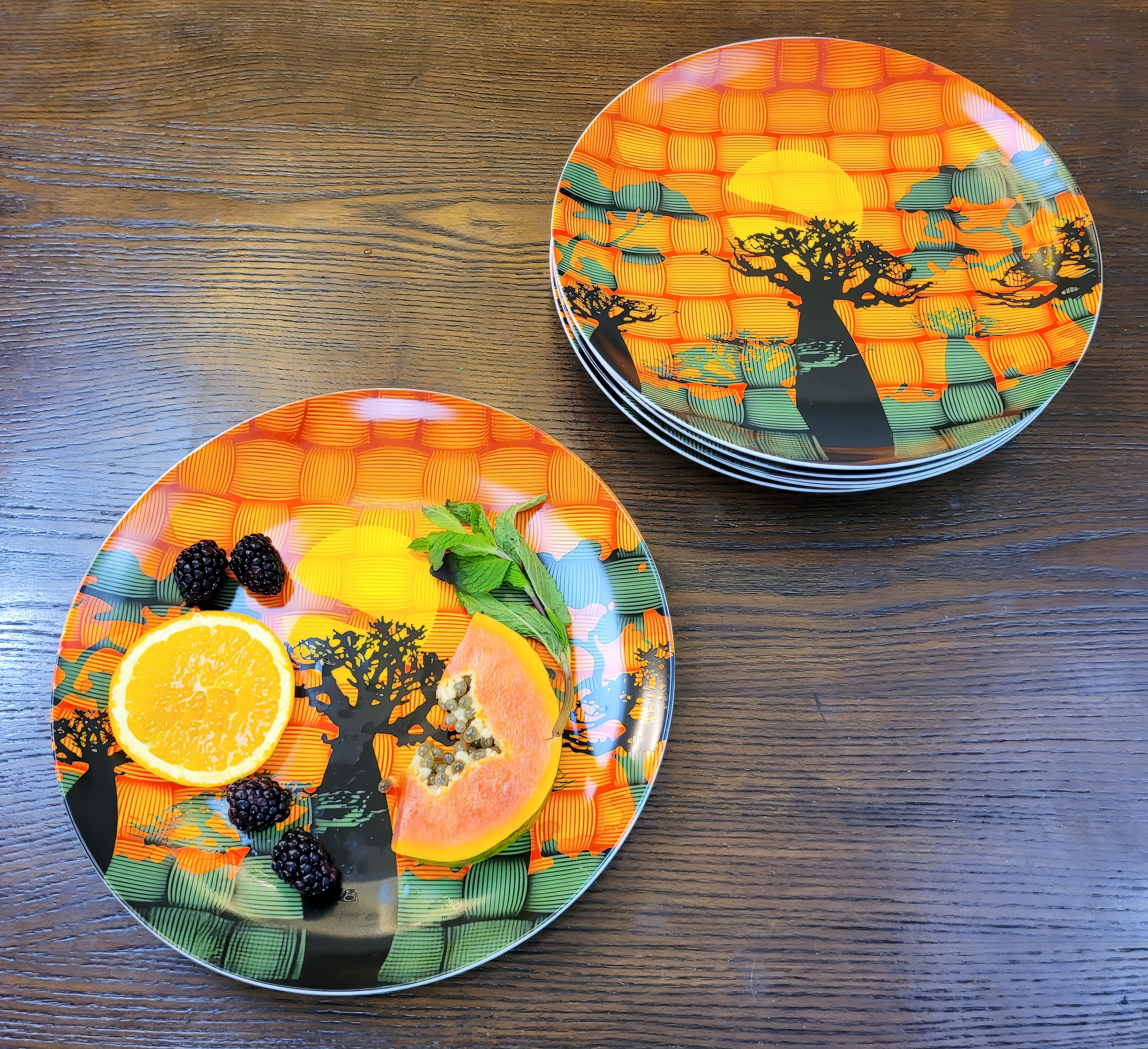 Beautiful ceramic plates with art of a African Baobab forrest. There are fruits on one of the plates